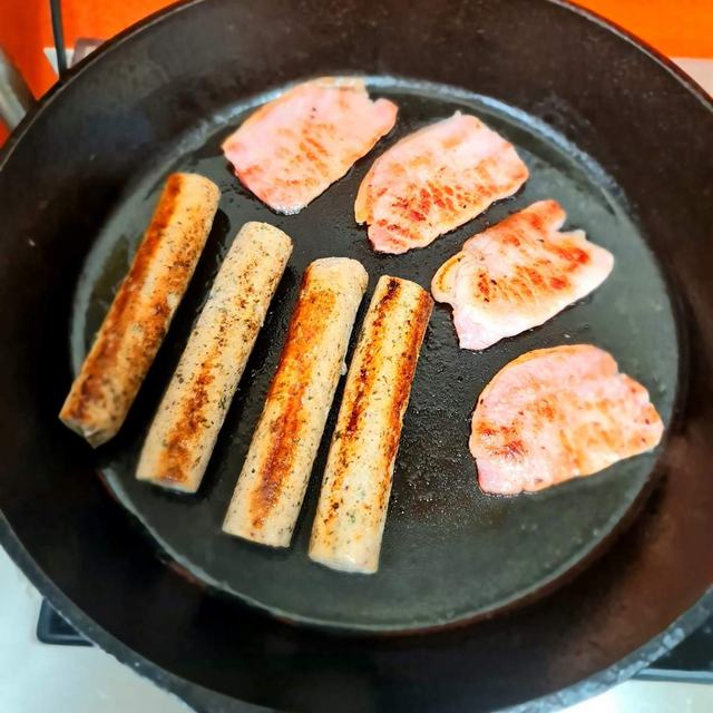 Sausages and bacon in a skillet